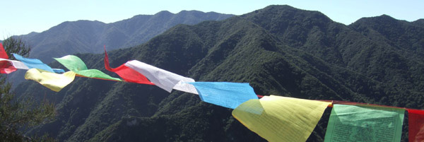 Tassajara guest season in the news header, prayer flags with mountain vista